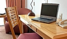 © Fotolia/John Tomaselli, Hotelzimmer mit Laptop auf einem Tisch © Fotolia/John Tomaselli, Hotelzimmer mit Laptop auf einem Tisch