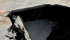 � AP/chuck crow, Gro�es Loch in einer Stra�e.