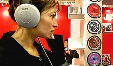 � Reuters/Eric Gaillard, Eine Konsumentin h�rt bei einem Messestand Musik mit Kopfh�rern