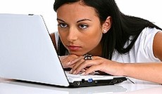 � Fotolia/bilderbox, Frau blickt nachdenklich auf Laptop.