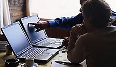 � Fotolia/daniel sainthorant, Zwei M�nner betrachten zwei Notebook-Monitore.